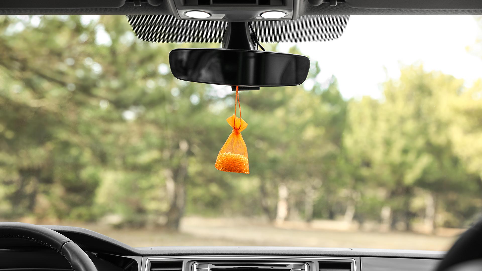 Air freshener hanging on rear view mirror in car