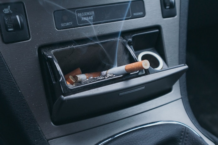 Zigarette in einem Aschenbecher im Auto 